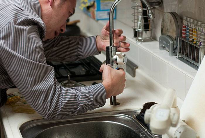 Plumber working in a kitchen
